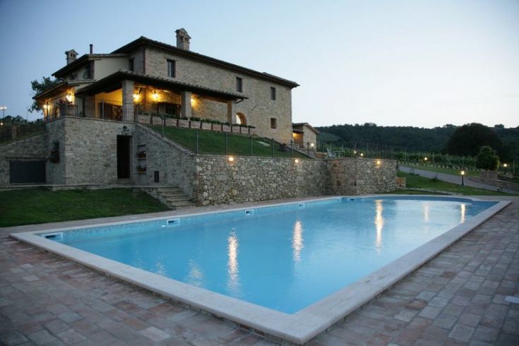 Historic 18th-century building with a pool, surrounded by vineyards and beautiful scenery.