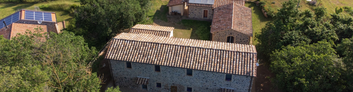 Una casa rurale con tre strutture, circondata dalla natura, che offre comfort moderni e pratiche sostenibili.