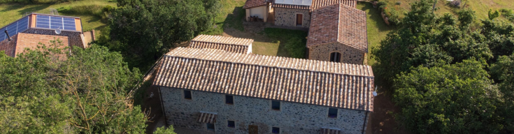A rural house with three buildings, surrounded by nature, providing modern comforts and sustainable practices.