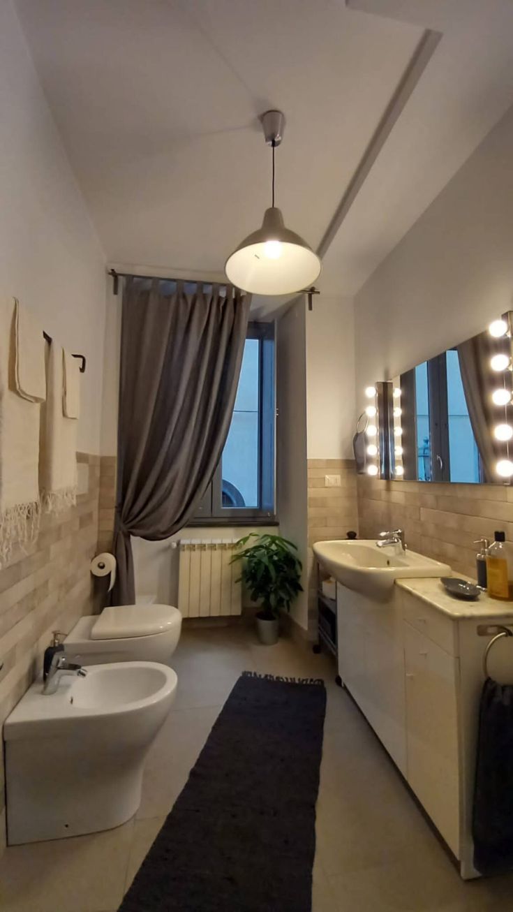 Bagno pratico e luminoso, con tonalità chiare, sanitari funzionali e ampio specchio.