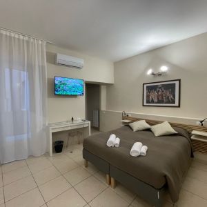 Camera semplice con letto matrimoniale, TV e aria condizionata. WiFi disponibile.