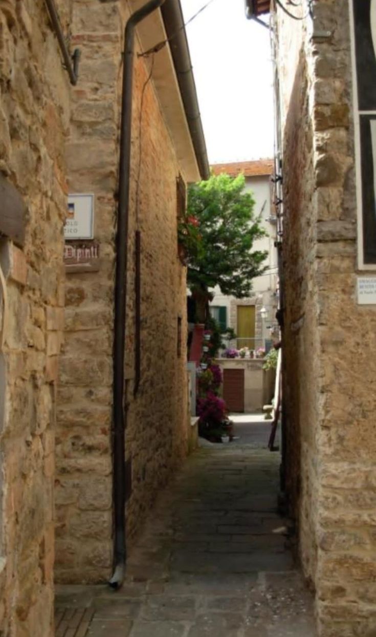 Eine ruhige Gasse in einem umbrischen Dorf mit dekorierten Wänden und einer einladenden Atmosphäre.