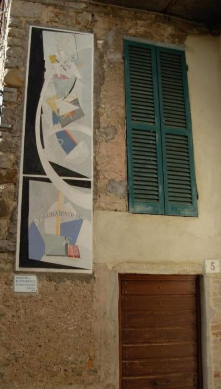 Ein farbenfrohes Wandgemälde an einer steinernen Wand eines Gebäudes, typisch für ein umbrisches Dorf.