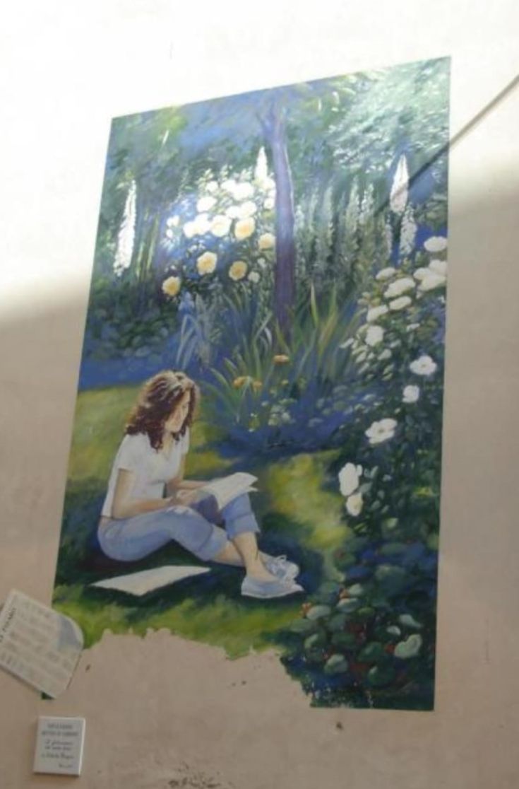 Ein Wandgemälde, das ein Mädchen beim Lesen zeigt, umgeben von einem bunten Blumengarten.