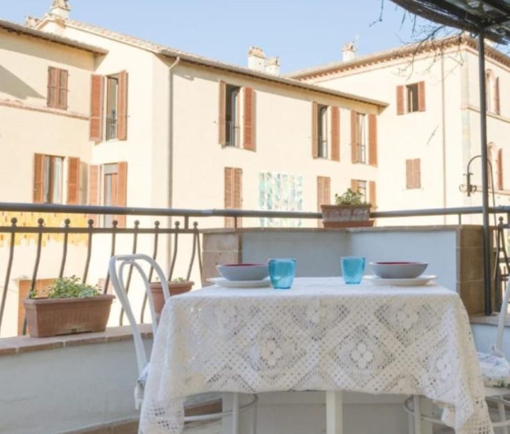 Terrasse mit einem Tisch, der auf historische Gebäude blickt, perfekt für entspannende Momente im Freien.