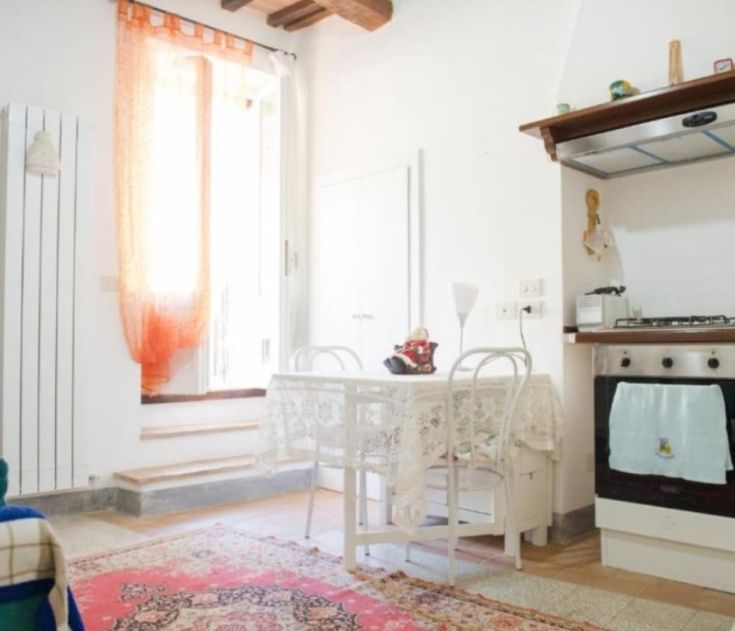 Einfache und helle Küche mit einem Tisch und schlichten Dekorationen, ideal für ruhige Momente.