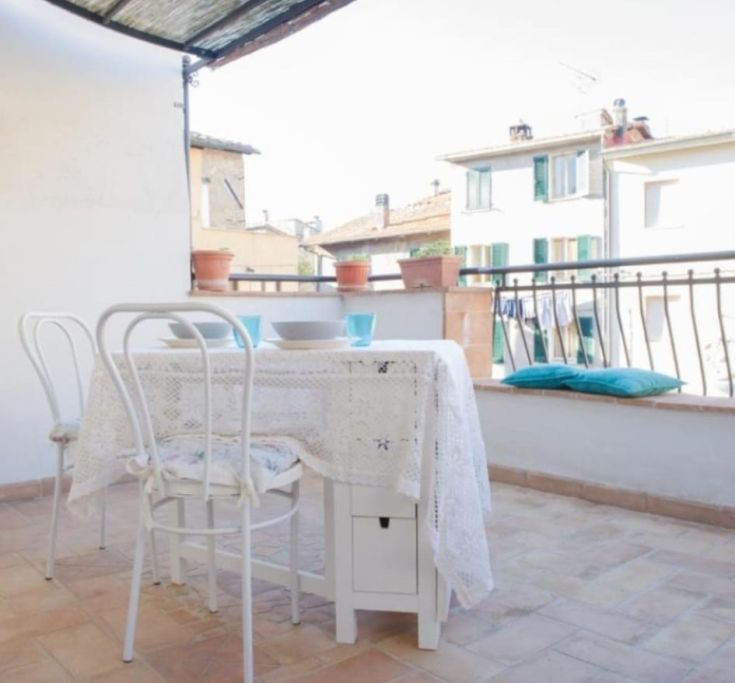 Ein ruhiger Balkon in einem historischen Dorf in Umbrien, ideal für Essens im Freien und Entspannung.