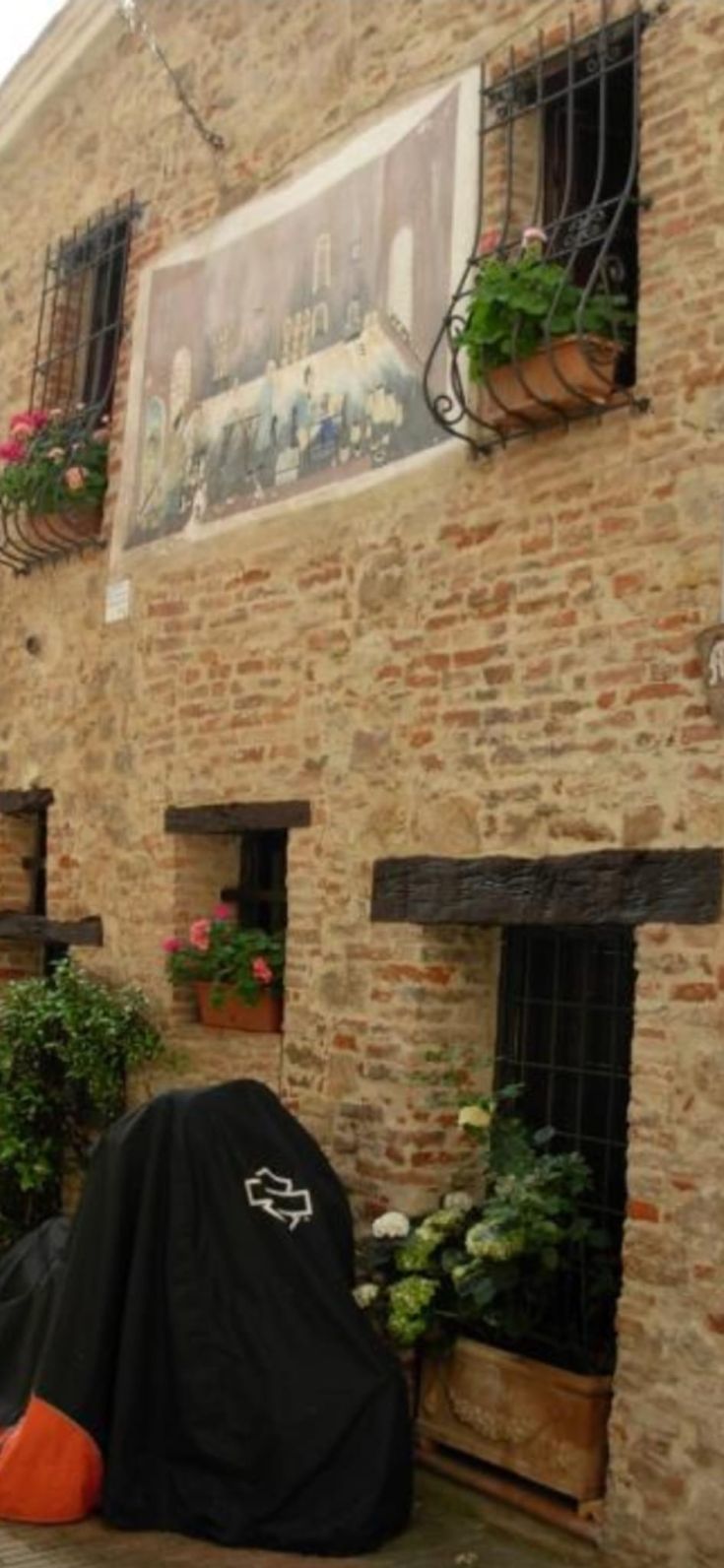 Eine Ecke des Ferienhauses Al Castello in Mugnano, mit dekorierten Wänden und blühenden Pflanzen.