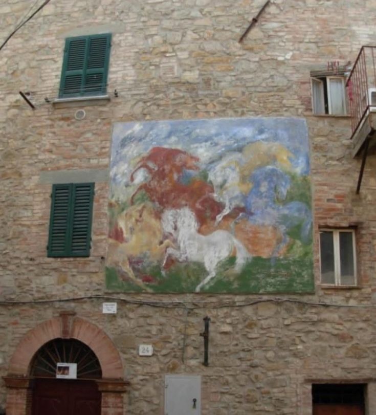 Wandgemälde mit Pferden an einer Wand eines Gebäudes in einem Dorf in Umbrien. Schlichte und einfache Dekorationen.