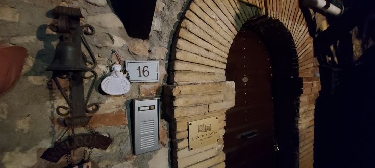 Dettagli di un palazzo usato come struttura ricettiva, con campanello e numeri civici in evidenza.