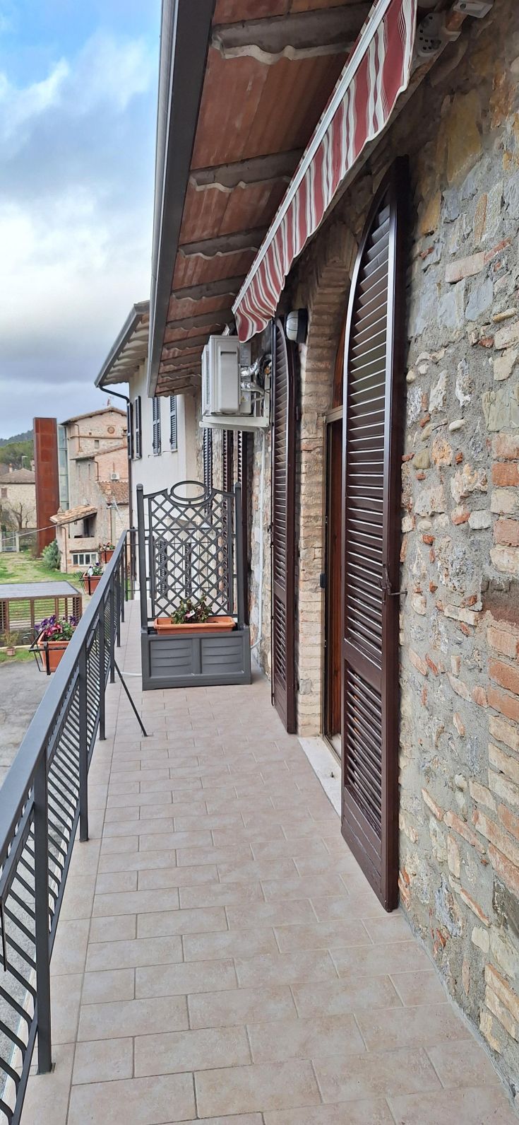 Un'accogliente terrazza che si affaccia su un caratteristico borgo umbro, perfetta per godere della natura e del relax.