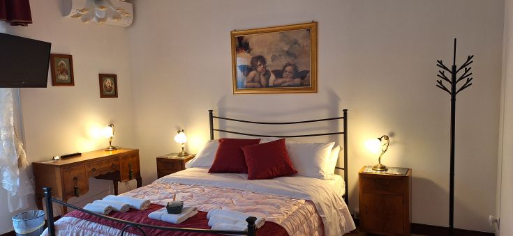 Camera luminosa con arredi semplici e comfort essenziali, adatta a un soggiorno rilassante.