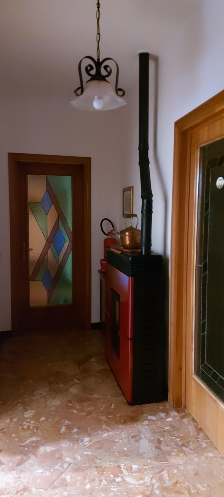 Un ingresso ben curato con dettagli semplici ed un camino rosso in bella vista.