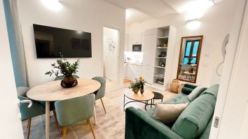 Soggiorno luminoso con area pranzo e cucina, arredato con elementi contemporanei e funzionali.