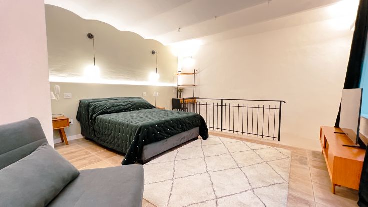 Gemütliches Doppelzimmer, schlicht eingerichtet, mit einem großen Fenster.