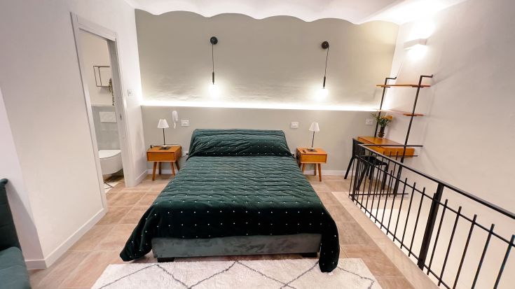 Einfaches Schlafzimmer mit Doppelbett, hellen Räumen und modernem Mobiliar. Ein komfortabler Ort zum Ausruhen.