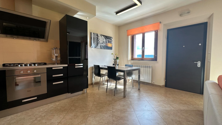 Ambiente accogliente e luminoso, con cucina e area pranzo, perfetto per momenti di relax.