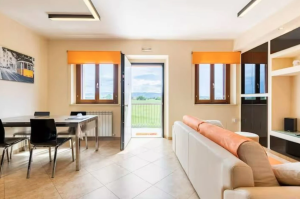 Ampio soggiorno con panorama sulle campagne umbre, pensato per momenti di relax e convivialità.