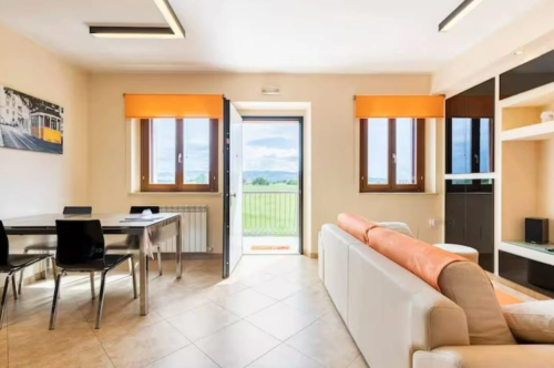 Spacious living room with a view of the Umbrian countryside, designed for relaxation and social gatherings.