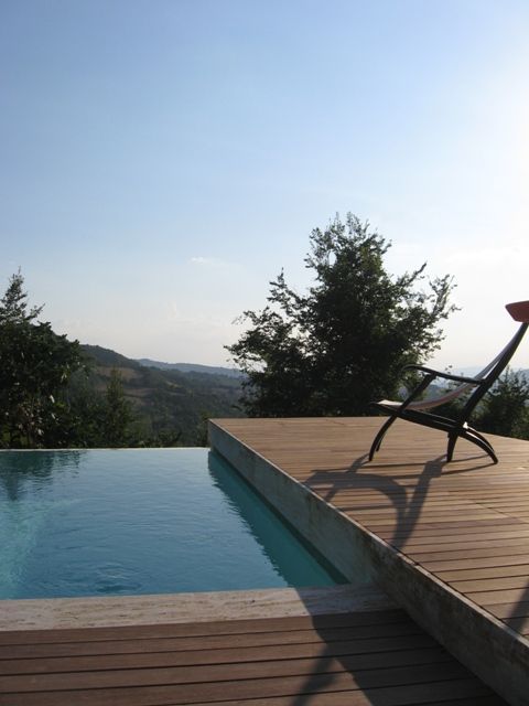Une piscine à débordement nichée dans la nature, située sur une colline paisible.