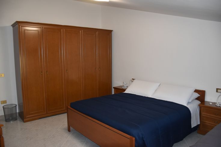 Chambre agréable avec un lit double et une armoire, bénéficiant de lumière naturelle pour un séjour confortable.