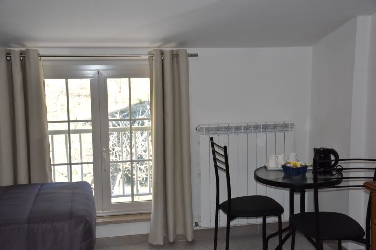 Chambre bien éclairée, équipée d'une table et de chaises, idéale pour un séjour relaxant.