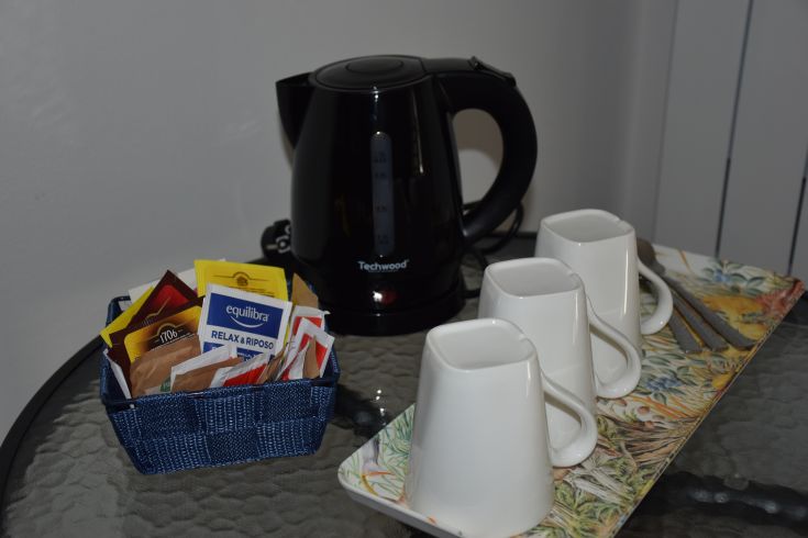 Un environnement détendu avec une bouilloire, des tasses et une sélection de thés variés.