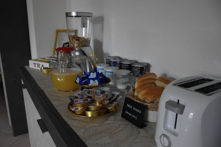Petit déjeuner au B&B avec du pain frais, du yaourt et des jus. Un cadre agréable pour commencer la journée.