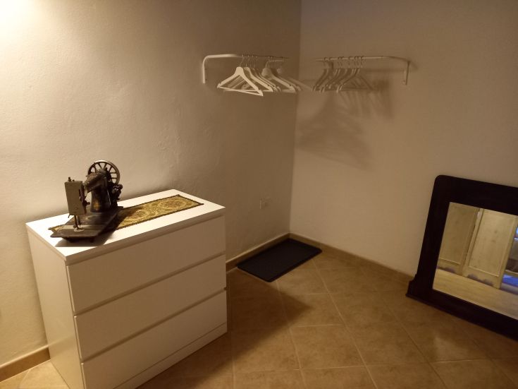 Camera luminosa e spaziosa, caratterizzata da un mobile d'epoca e una macchina da cucire decorativa.