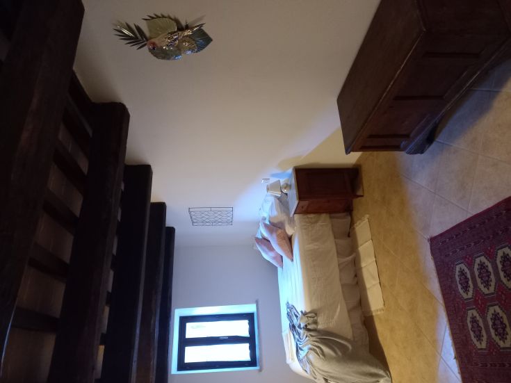 Ambiente confortevole con letto matrimoniale e elementi in stile rustico, perfetto per una fuga rilassante.