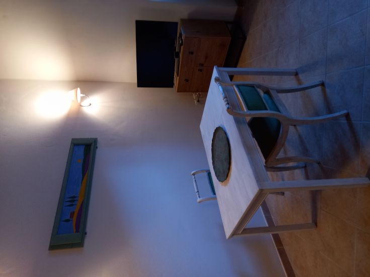 Un semplice angolo soggiorno con un tavolo e una parete decorata, adatto per momenti di relax.