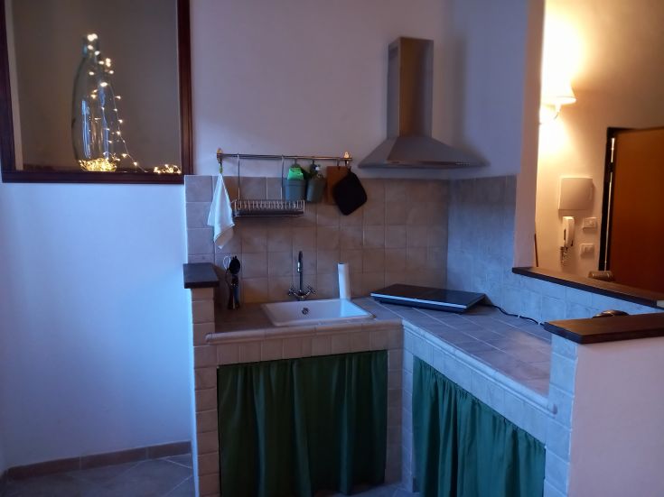 Cucina spaziosa con dettagli ordinati e un angolo studio, perfetta per momenti di relax.