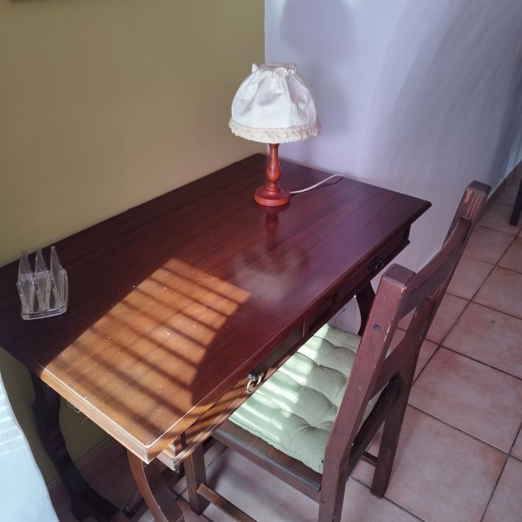 Angolo tranquillo con un tavolo in legno e una lampada, creando un'atmosfera serena.