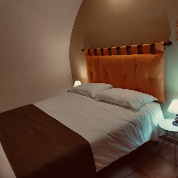 Camera da letto semplice con arredi pratici e una luce tenue per un'atmosfera rilassante.