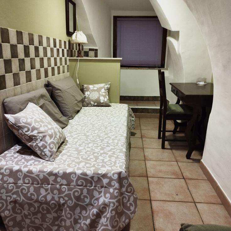 Ambiente semplice con un divano, un tavolo e decorazioni neutre.