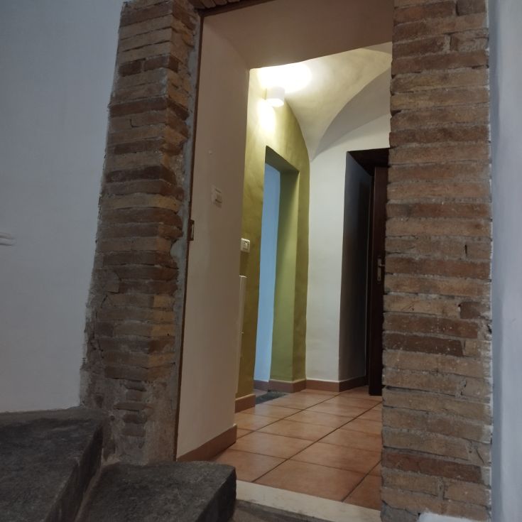 Porta d'ingresso che porta a un ambiente ristrutturato, con elementi architettonici semplici.