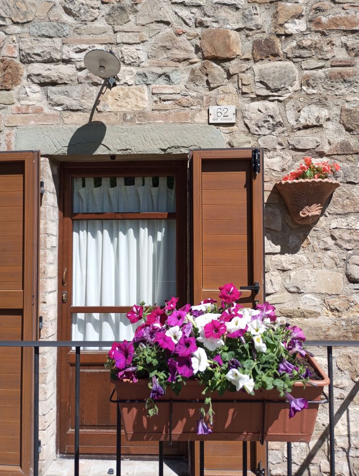 Eine einfache Tür mit einer bunten Blumenvase daneben.