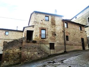 A stone building with stairs and windows located in a charming village.
