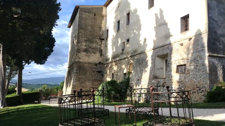 A historic building surrounded by greenery, featuring interiors that blend rustic and modern styles.