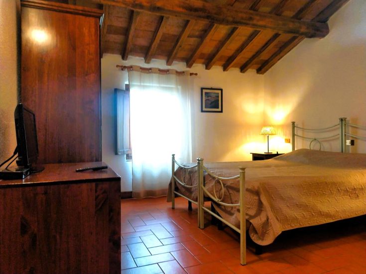 Cozy room with a double bed and rustic furniture, perfect for a peaceful stay.