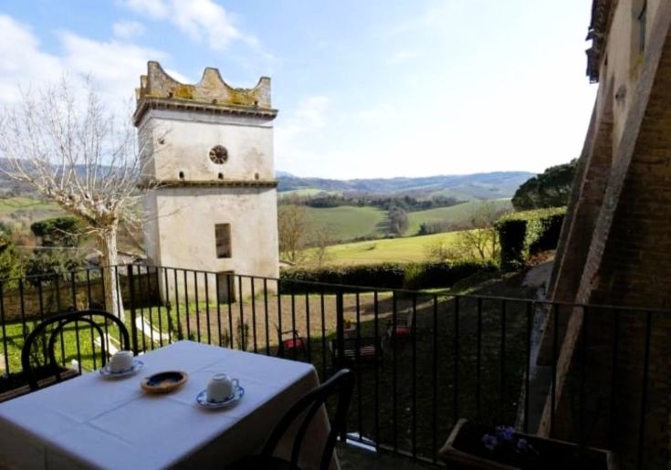 Panoramic view of a hilly landscape featuring a historic building. A table set in a serene environment.