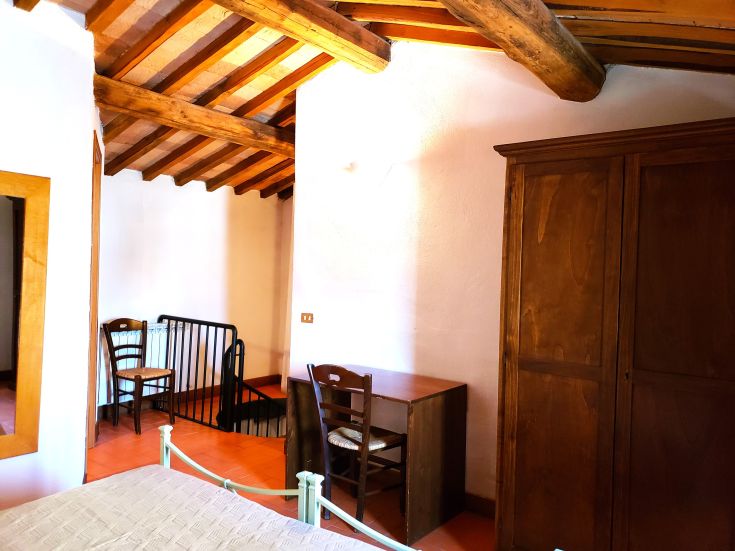 Simple room with wooden furniture, beds, and a desk, ideal for a quiet stay.