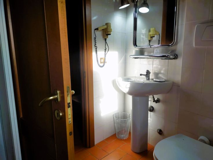 Modern bathroom featuring contemporary fixtures and a wooden door. Natural light fills the space.