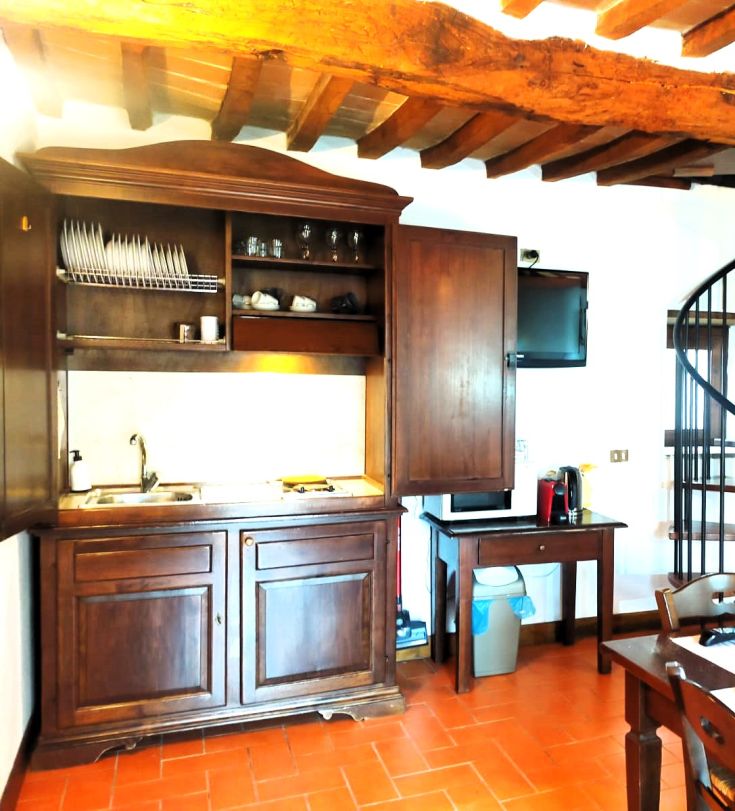 Simple wooden kitchen with a cooking corner, set in a relaxed and inviting environment.