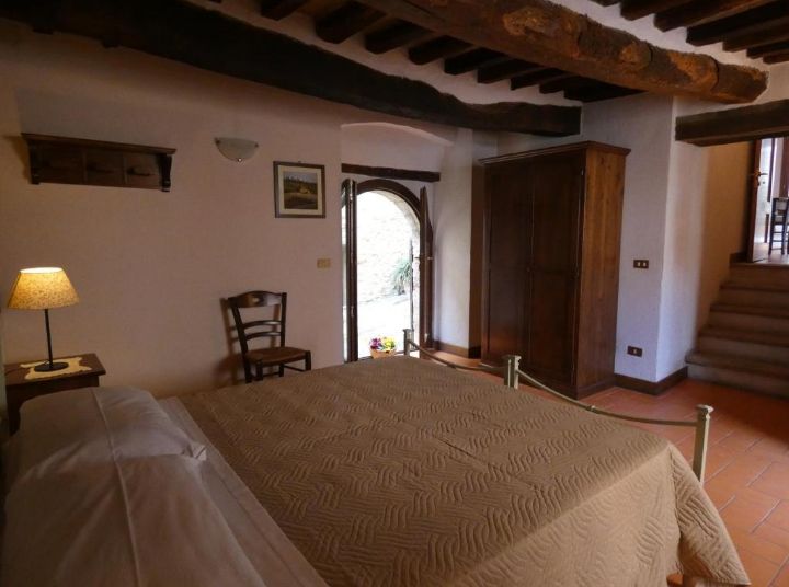 Cozy room with rustic furniture and a view of a peaceful courtyard. Perfect for a serene stay.
