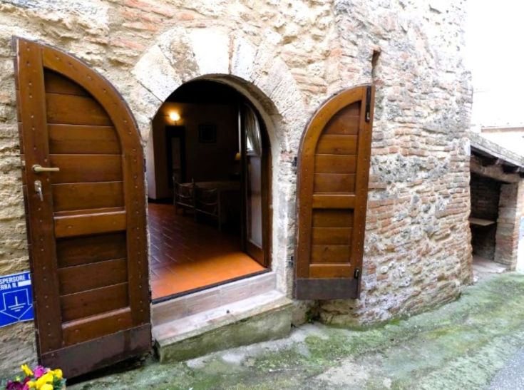 Entrance of a rustic building with wooden doors, exuding a cozy atmosphere.