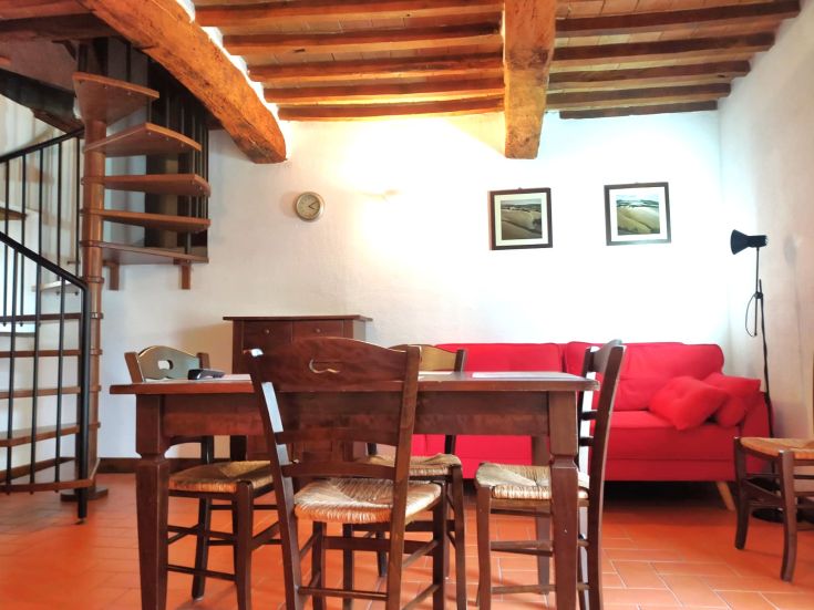 Cozy apartment with wooden furniture and a red sofa, offering a simple and comfortable atmosphere.