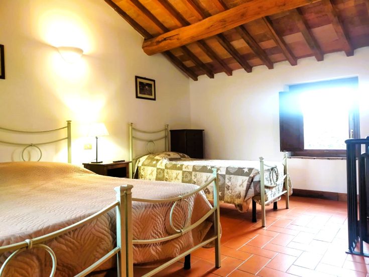 Simple room with iron beds and rustic furniture, perfect for a peaceful stay.