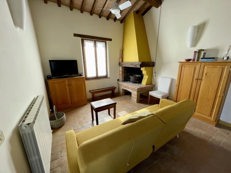 Un soggiorno confortevole con camino, televisore e mobili in legno, perfetto per momenti di svago e tranquillità.