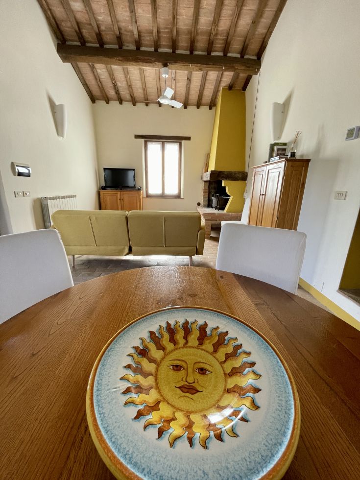 Una sala confortevole con un tavolo in legno e un piatto decorativo, perfetta per momenti di relax.